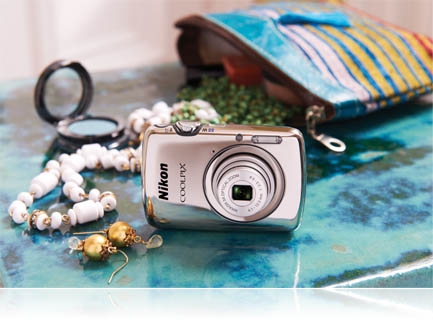 photo of the COOLPIX S01 with contents of an open purse on a table